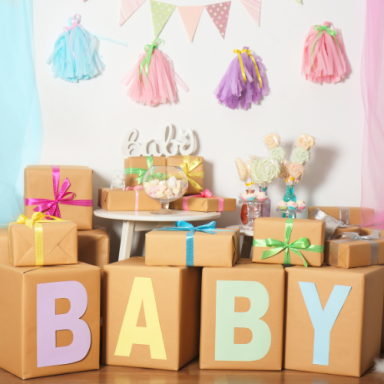 Décor de fête pour bébé avec boîtes cadeaux et guirlandes colorées.