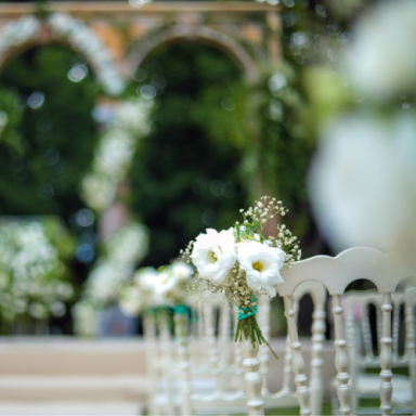 Chaises blanches décorées de fleurs blanches et feuillage, cadre de cérémonie florale.