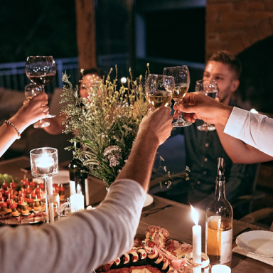 Célébration conviviale avec des verres levés autour d'une table garnie de mets.