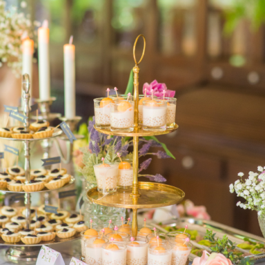 Vitrine de desserts élégants avec gâteaux en verrines et biscuits sur plusieurs niveaux.