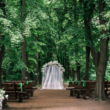 Cérémonie de mariage en plein air, avec des bancs en bois et un décor fleuri.
