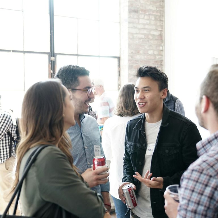 Groupe d'amis discutant dans un espace lumineux et convivial.